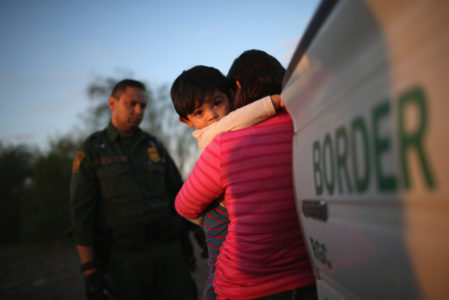Un niño de un año de edad de El Salvador se abraza a su madre después de entregarse a agentes de la “Border Patrol”  en diciembre 7, 2015 cerca de Rio Grande City, Texas.