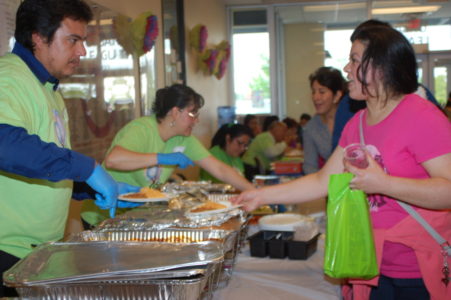 Los asistentes al evento compartiendo comida con sabor latina.