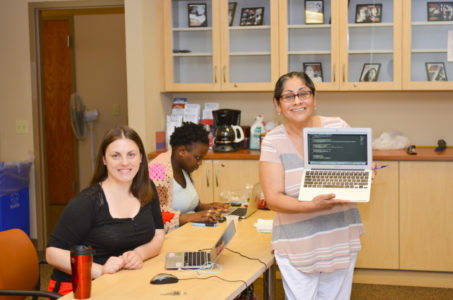 Tres estudiantes, entre ellas Beatriz Kellman mostrando en medio de una asignación en los computadores que brinda el propio curso a cada alumno.