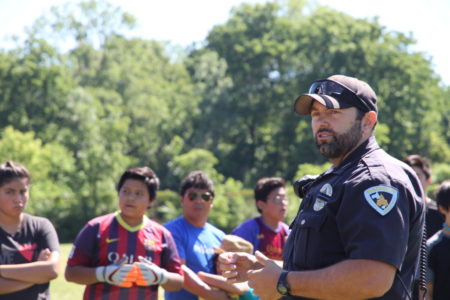 Oficial de policía Mike Álvarez, dirige y organiza el evento deportivo para los niños
